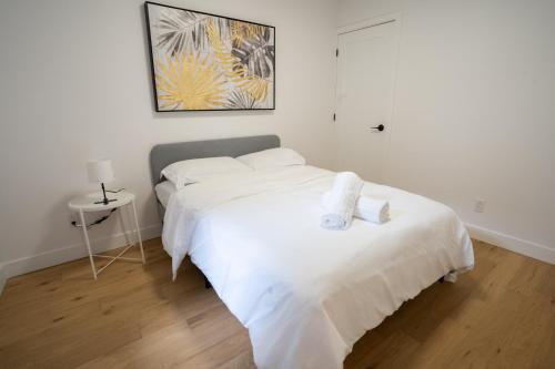 biała sypialnia z łóżkiem z białą pościelą w obiekcie Beautifully Renovated 3BR Downtown 2min to METRO w Montrealu