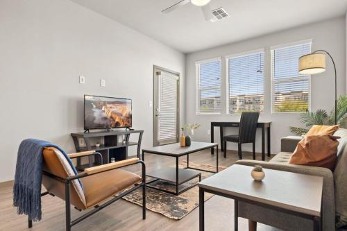 a living room with a couch and a tv at Stunning Westgate CozySuites by stadium with pool 10 in Glendale