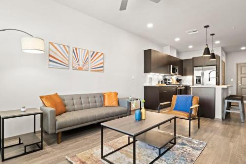 a living room with a couch and tables and a kitchen at Stunning Westgate CozySuites by stadium with pool 10 in Glendale