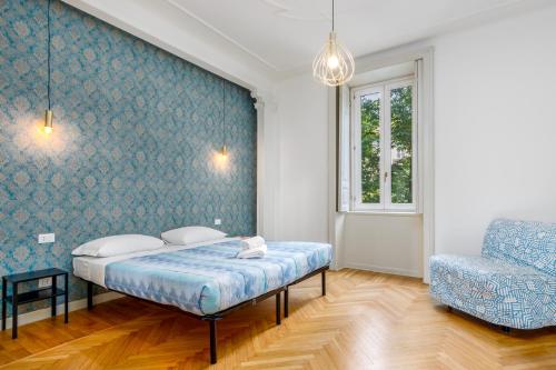 1 dormitorio con 1 cama y 1 silla en FEEL - Palazzo Centrale en Bérgamo