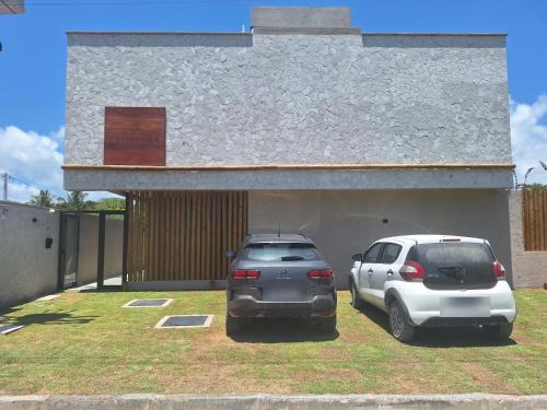 two cars parked in a parking lot in front of a building at Refúgio a Poucos Passos do Mar l Milagres Hospedagens in Pôrto de Pedras