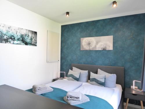 een slaapkamer met 2 bedden en blauwe muren bij Winterberg Cityflair Wifi Pool Sauna 6 Pers PS4 Netflix near Bikepark in Winterberg