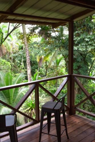 a wooden porch with a chair and trees at The Lodge at Punta Rica- Hilltop Eco-Lodge with Views & Pool in Bastimentos