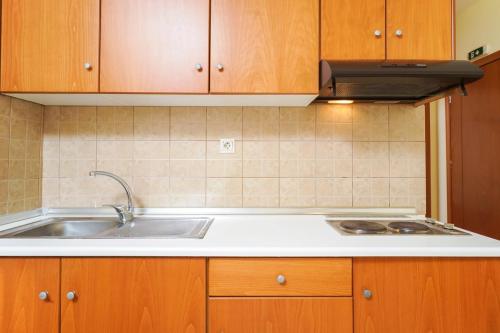 a kitchen with a sink and a stove at Ladikas apartments in Chrysi Ammoudia