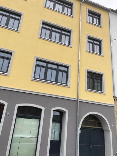 a yellow building with black windows at SUITE-DREAMS APARTMENT - Innenstadt in Hannover