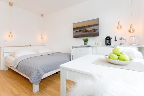 um quarto branco com uma cama e uma tigela de maçãs em Beach Vibes em Timmendorfer Strand