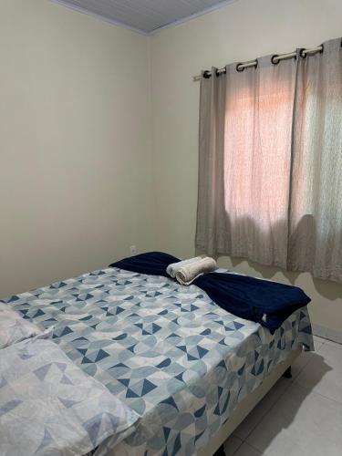 Bett in einem Zimmer mit Fenster in der Unterkunft Flat próx. Rodov. e Aeroporto in Palmas