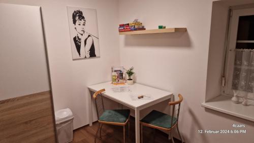 a small white table and chairs in a room at Voll ausgestattet, Nähe Heiltherme Bad Waltersdorf in Ebersdorf