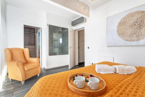 um quarto com uma cama com uma colcha laranja e uma cadeira em Host Wise - Luxurious House with Private Salt Pool em Ferragudo