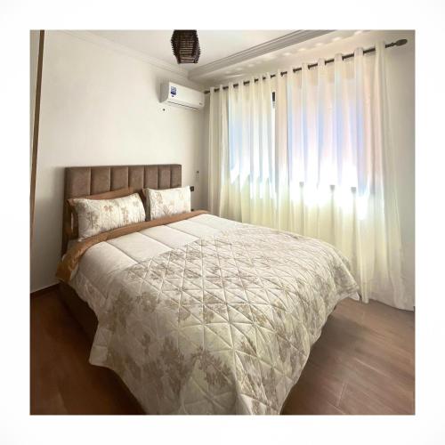 um quarto com uma cama grande e uma janela em Flat gueliz em Marrakech