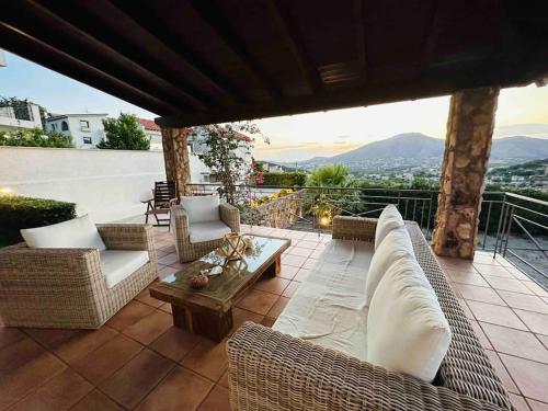 a patio with couches and a table and a view at Escape villa in Anavissos in Athens