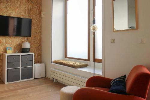 モントルイユにあるBeautiful renovated studio in dynamic neighborhoodのリビングルーム(赤い椅子、窓付)