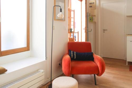 モントルイユにあるBeautiful renovated studio in dynamic neighborhoodの赤い椅子(窓際に枕付)