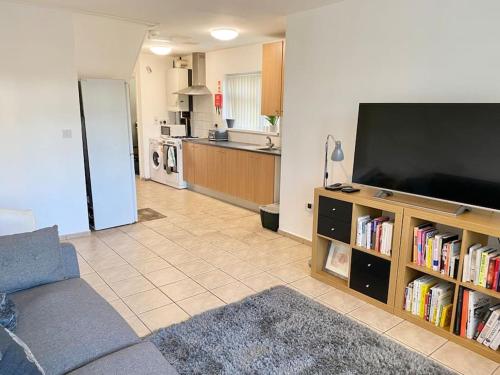 ein Wohnzimmer mit einem Flachbild-TV und eine Küche in der Unterkunft In Royal Leamington Spa 4 bed with free parking in Leamington Spa