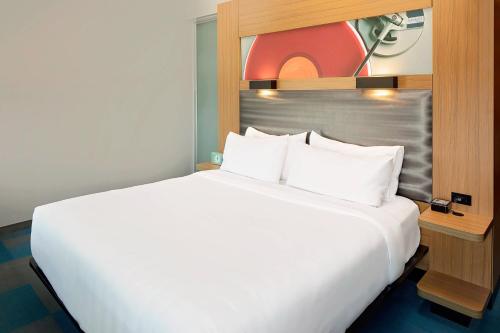 a large white bed in a hotel room at aloft Green Bay in Green Bay