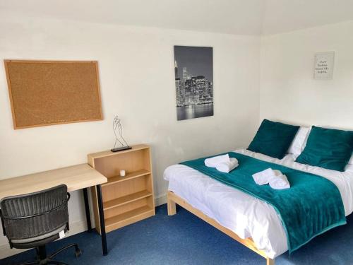 sypialnia z łóżkiem i biurkiem oraz łóżko o wymiarach 6 x 6 x 6 w obiekcie In Royal Leamington Spa 4 bed with free parking w mieście Leamington Spa