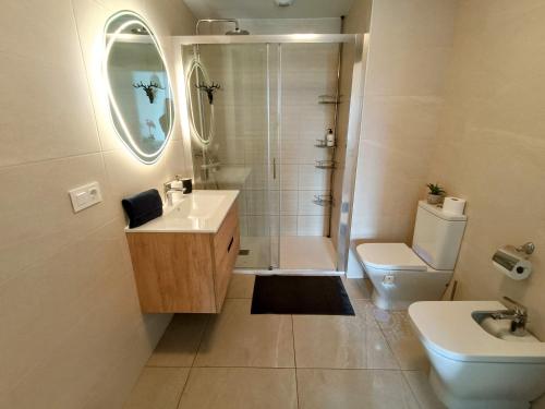 a bathroom with a shower and a sink and a toilet at Luxury Las Canteras, pool & gym in Las Palmas de Gran Canaria