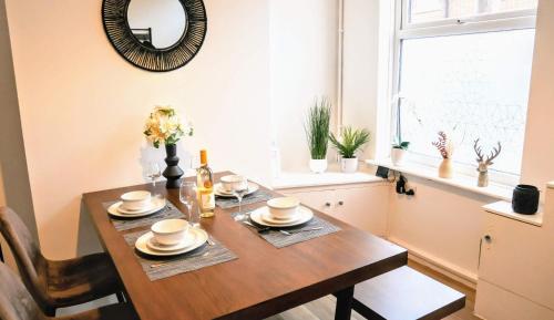 a dining room with a table and a mirror at Stoke - 3 Bedroom House - Winifred St. in Stoke on Trent