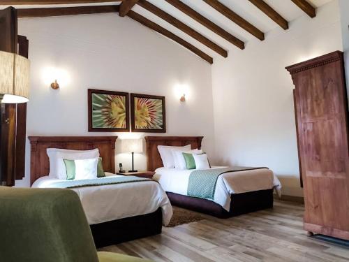 a hotel room with two beds and a couch at Casa Passiflora Hotel Boutique in Jardin