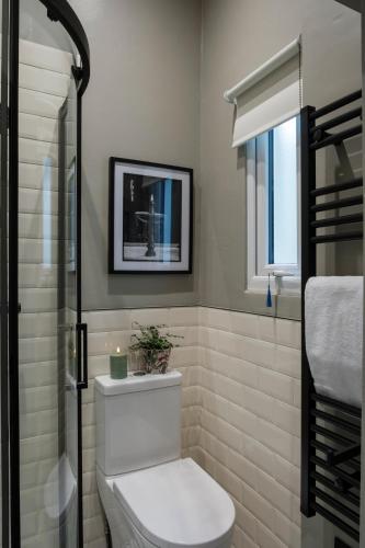 a bathroom with a white toilet and a window at 5&6 North Place in Gloucestershire