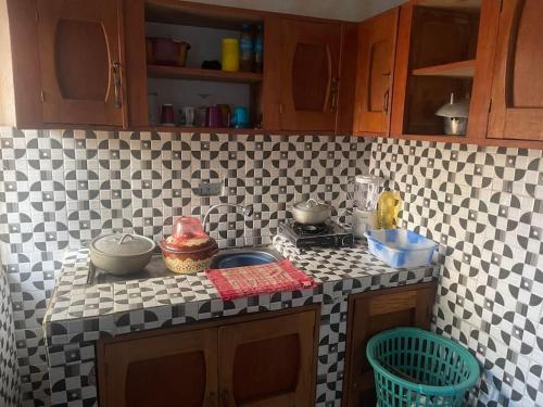 a kitchen with a black and white tiled counter top at Theresa Lodge. in Port Loko