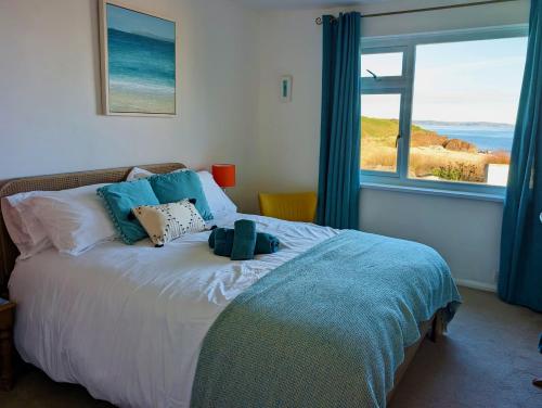 a bedroom with a bed with a view of the ocean at Beach Front Coastal Retreat with Sea Views in Kingsbridge