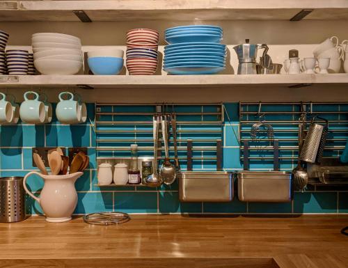 a kitchen with plates and dishes on shelves at Beach Front Coastal Retreat with Sea Views in Kingsbridge