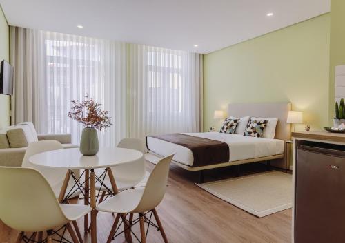 a bedroom with a bed and a table and chairs at Primeiro Quartel Apartments - 2 in Peso da Régua