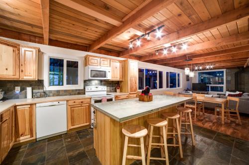 a kitchen with wooden cabinets and a large island with bar stools at Snowline Cabin 66 - Hot Tub - Wi-Fi - 3 Bedroom - Sleeps 10 in Deming