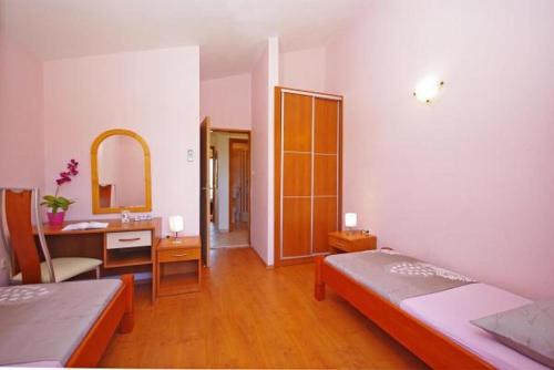 - une chambre avec 2 lits, un bureau et un miroir dans l'établissement Apartment in Zaton (Zadar) with sea view, loggia, air conditioning, Wi-Fi (4810-4), à Zaton