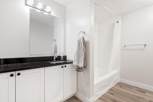 a white bathroom with a sink and a shower at 14 minutes from downtown, brand new home in Ottawa in Ottawa