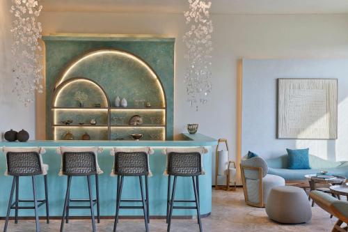 a living room with a bar with four stools at The St. Regis Red Sea Resort in Ḩanak