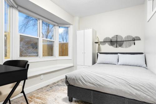 um quarto com uma cama, uma secretária e janelas em 14 minutes from downtown, brand new home in Ottawa em Ottawa