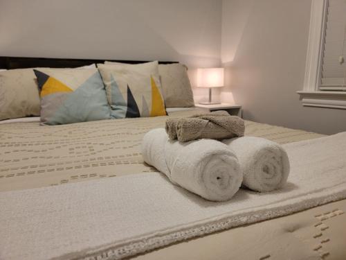 a bedroom with a bed with towels on it at Le Cozy Clover in Moncton