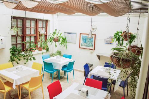 un restaurante con mesas, sillas y plantas en CASA HOTEL ALNOR, en Medellín