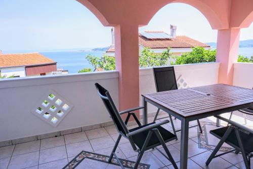 a table and chairs on a balcony with a view of the ocean at Apartment Stefica in Crveni Vrh
