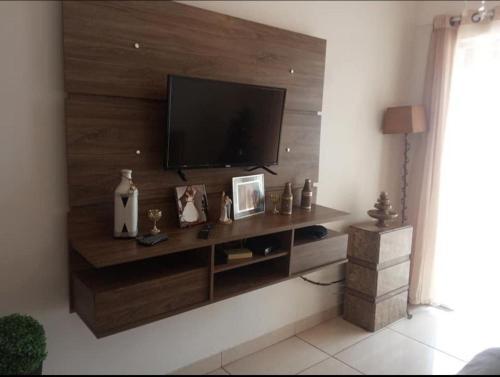 uma sala de estar com uma televisão de ecrã plano na parede em Casa a 40 minuto da praia no Rio de Janeiro