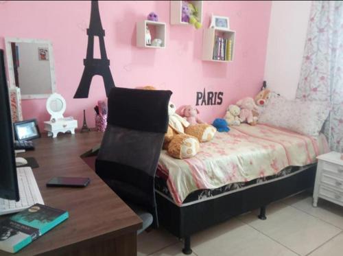 a pink bedroom with a bed with stuffed animals on it at Casa a 40 minuto da praia in Rio de Janeiro