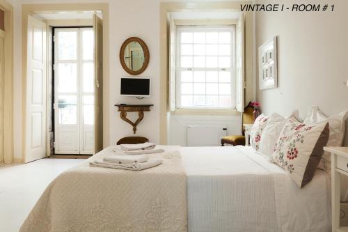 een slaapkamer met een wit bed en handdoeken bij Alfama Vintage 1 Ten guests - Alfama Vintage 2 Five guests - Alfama Vintage 3 Three Guests in Lissabon