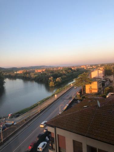 a view of a river with cars parked on a street at Skyscraper Apartment Pontedera in Pontedera