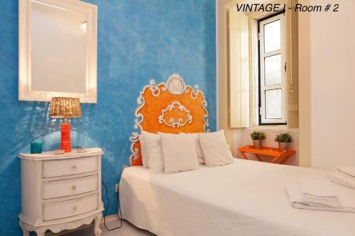 ein Schlafzimmer mit einem weißen Bett und einer blauen Wand in der Unterkunft Alfama Vintage 1 Ten guests - Alfama Vintage 2 Five guests - Alfama Vintage 3 Three Guests in Lissabon
