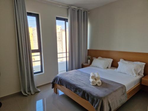 a bedroom with a bed with two towels on it at Apartamentos Beira-Mar in Mindelo