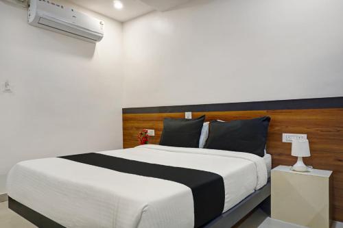 - une chambre avec un grand lit et une tête de lit en bois dans l'établissement Collection O Hotel Stay Prime Baner, à Pune