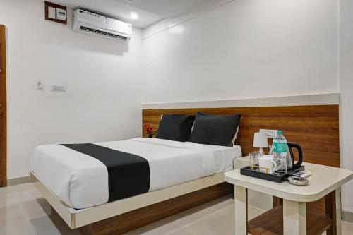 a bedroom with a large bed and a table at Collection O Hotel Stay Prime Baner in Pune