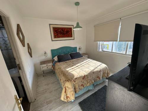 - une chambre avec un lit et une télévision à écran plat dans l'établissement Departamentos Quintaviña K15, à Viña del Mar