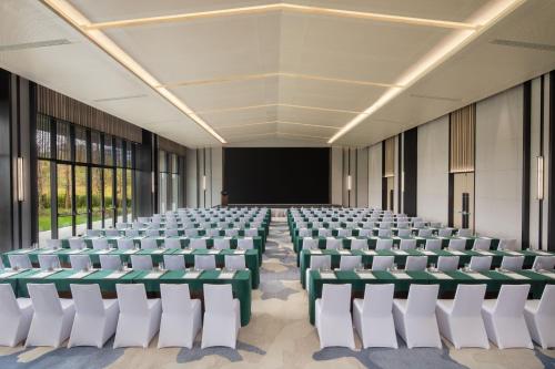 an empty lecture hall with white chairs and a screen at Fairfield by Marriott Bijie in Bijie