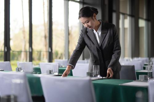 a man in a suit is standing at a table at Fairfield by Marriott Bijie in Bijie