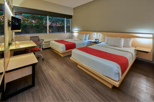 Habitación de hotel con 2 camas y escritorio en City Express by Marriott Chihuahua, en Chihuahua