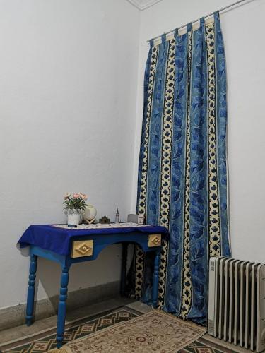 Dar mima baya في تونس: طاولة زرقاء مع ستارة زرقاء بجانب مشعاع