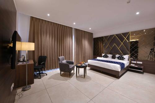 um quarto com uma cama, uma secretária e uma cadeira em Palette - Hotel Royal Palace Morbi em Morbi